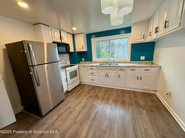 a kitchen with white cabinets and white stainless steel appliances