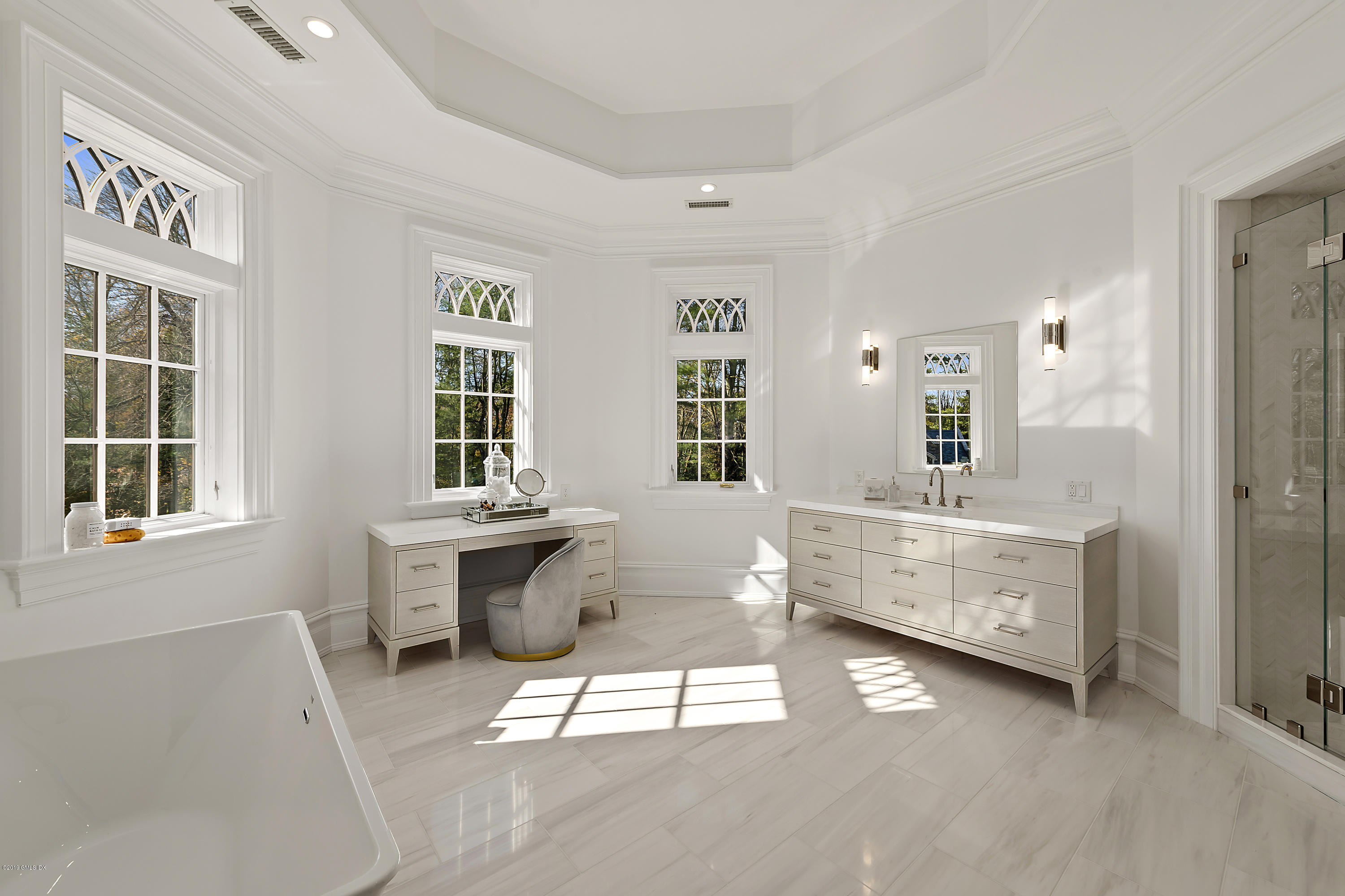 7 Loch Lane Greenwich, CT 06830 - Photo 26 of 41 a bathroom with a double vanity sink a mirror a bathtub and next to a window