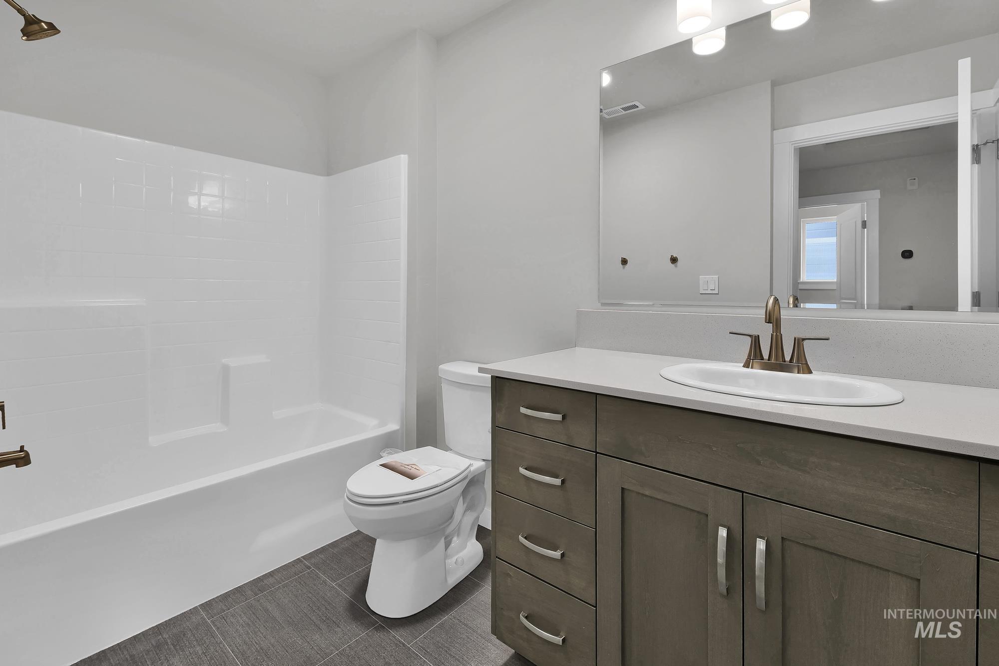 4328 West Topeka Lane Meridian, ID 83642 - Photo 9 of 14 Full bath featuring vanity, shower combination, and dark tile patterned floors