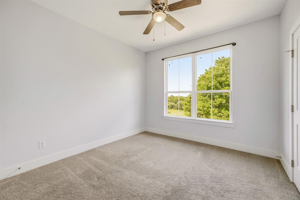 745 North Miller Avenue Stephenville, TX 76401 - Photo 22 of 31 Bright room featuring a large window with white trim, a multi-pane design, and an overhead ceiling fan with integrated lighting