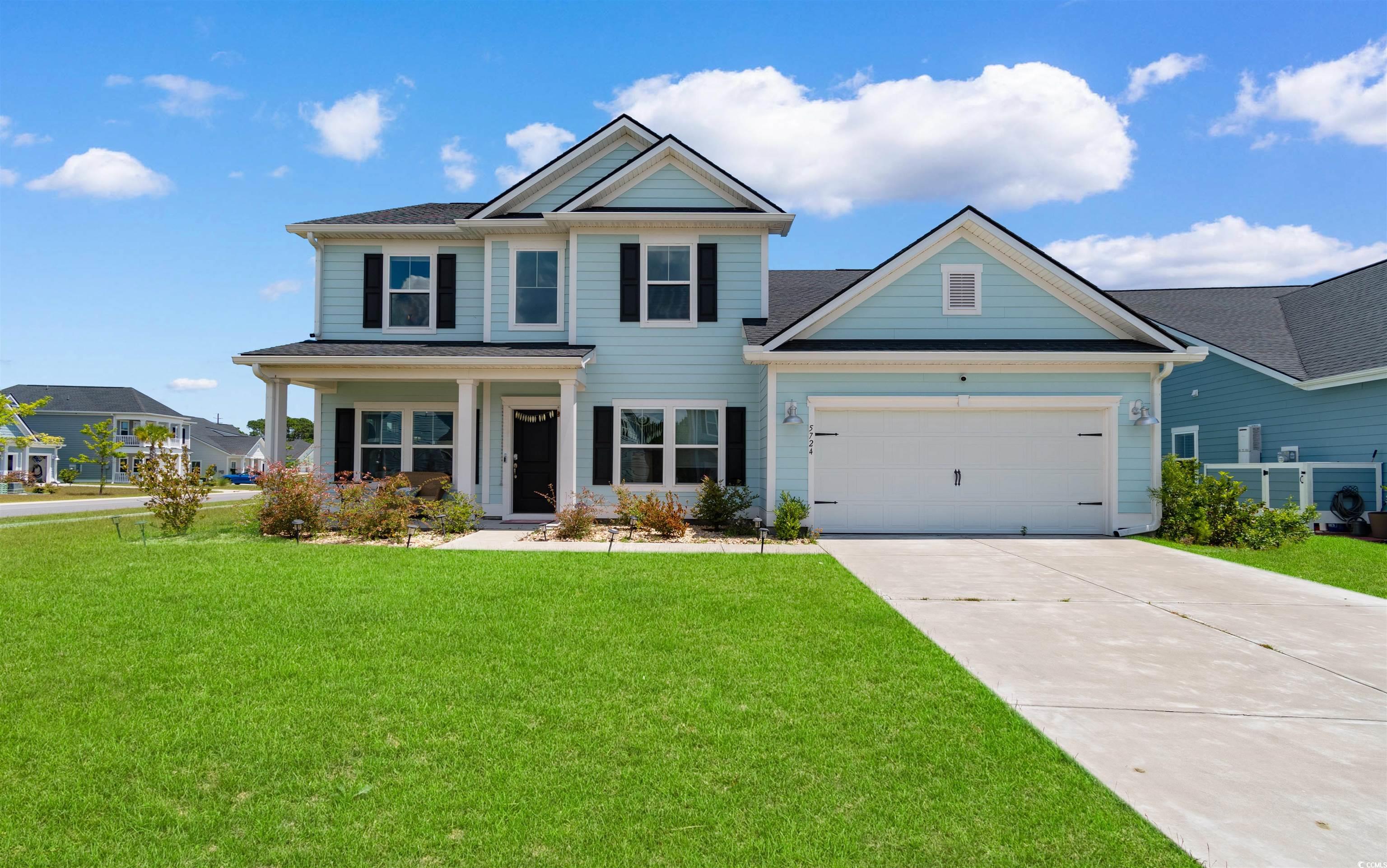Craftsman house with concrete driveway, a front lawn, and a garage