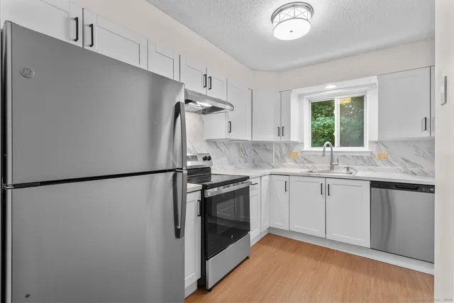 a kitchen with a refrigerator sink and window