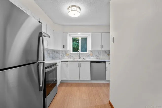 a kitchen with a refrigerator sink and window