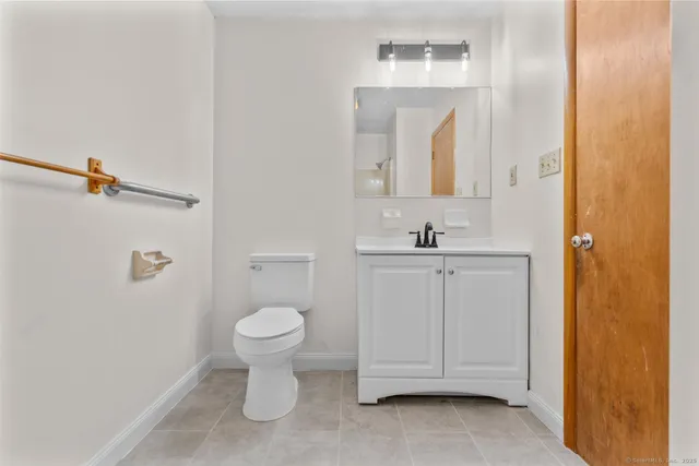 a bathroom with a toilet sink and mirror