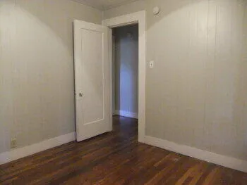 a view of an empty room with wooden floor