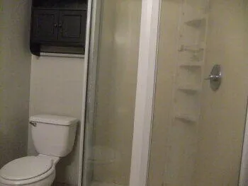 a white toilet sitting next to a shower