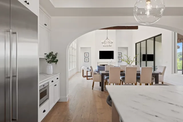 a kitchen with a stove a center island a dining table and chairs