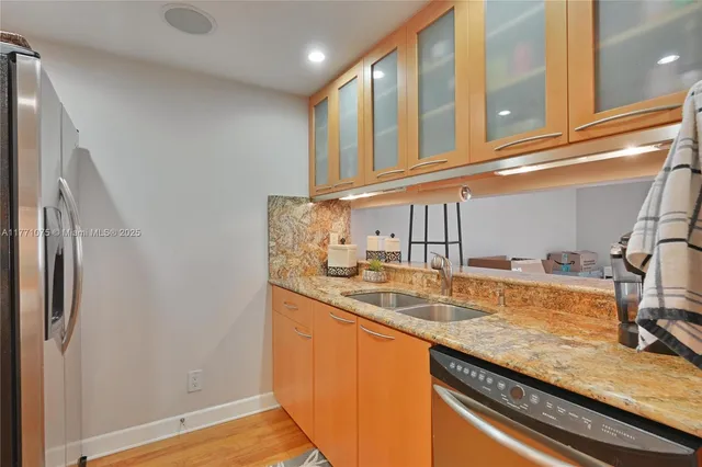 a kitchen with granite countertop a sink and a refrigerator