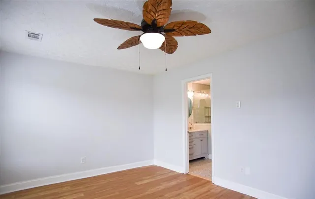 a view of a room with wooden floor and chandelier fan