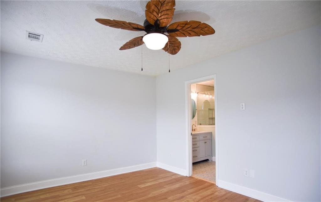 6616 Splashwater Drive Flowery Branch, GA 30542 - Photo 11 of 33 a view of a room with wooden floor and chandelier fan