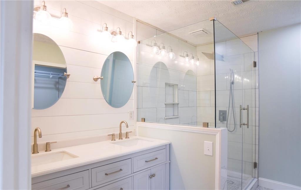 6616 Splashwater Drive Flowery Branch, GA 30542 - Photo 14 of 33 a bathroom with a double vanity sink mirror and shower