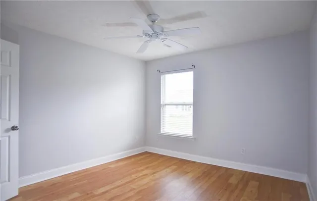 an empty room with a window and a fan