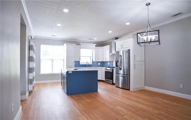 a view of kitchen with refrigerator microwave and stove top oven