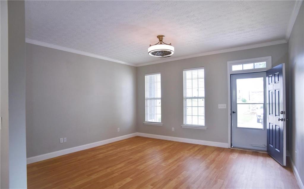 6616 Splashwater Drive Flowery Branch, GA 30542 - Photo 7 of 33 an empty room with wooden floor and windows