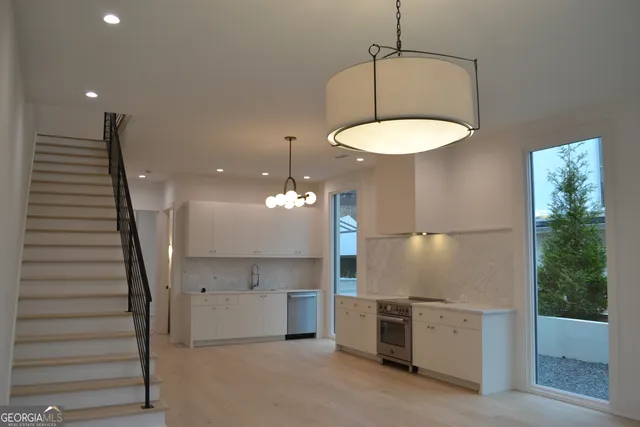 a kitchen with stainless steel appliances granite countertop a sink a refrigerator and a stove