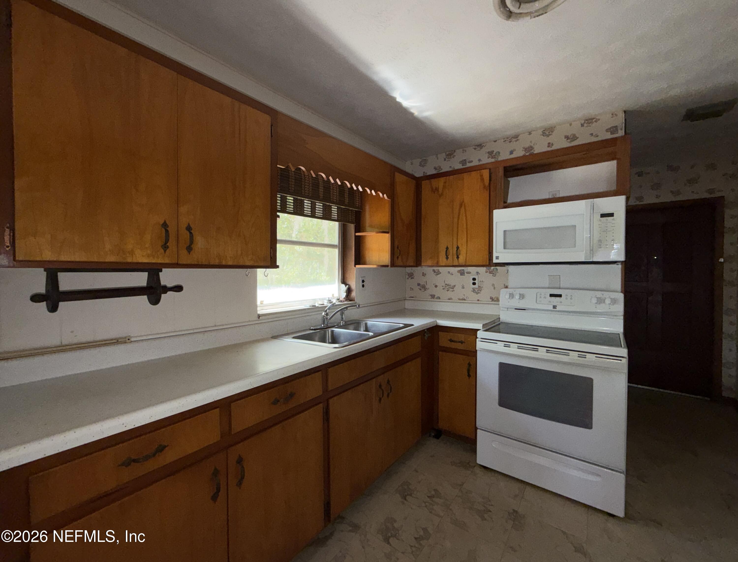 5943 White Sands Road Keystone Heights, FL 32656 - Photo 8 of 18 a kitchen with a sink stove and cabinets