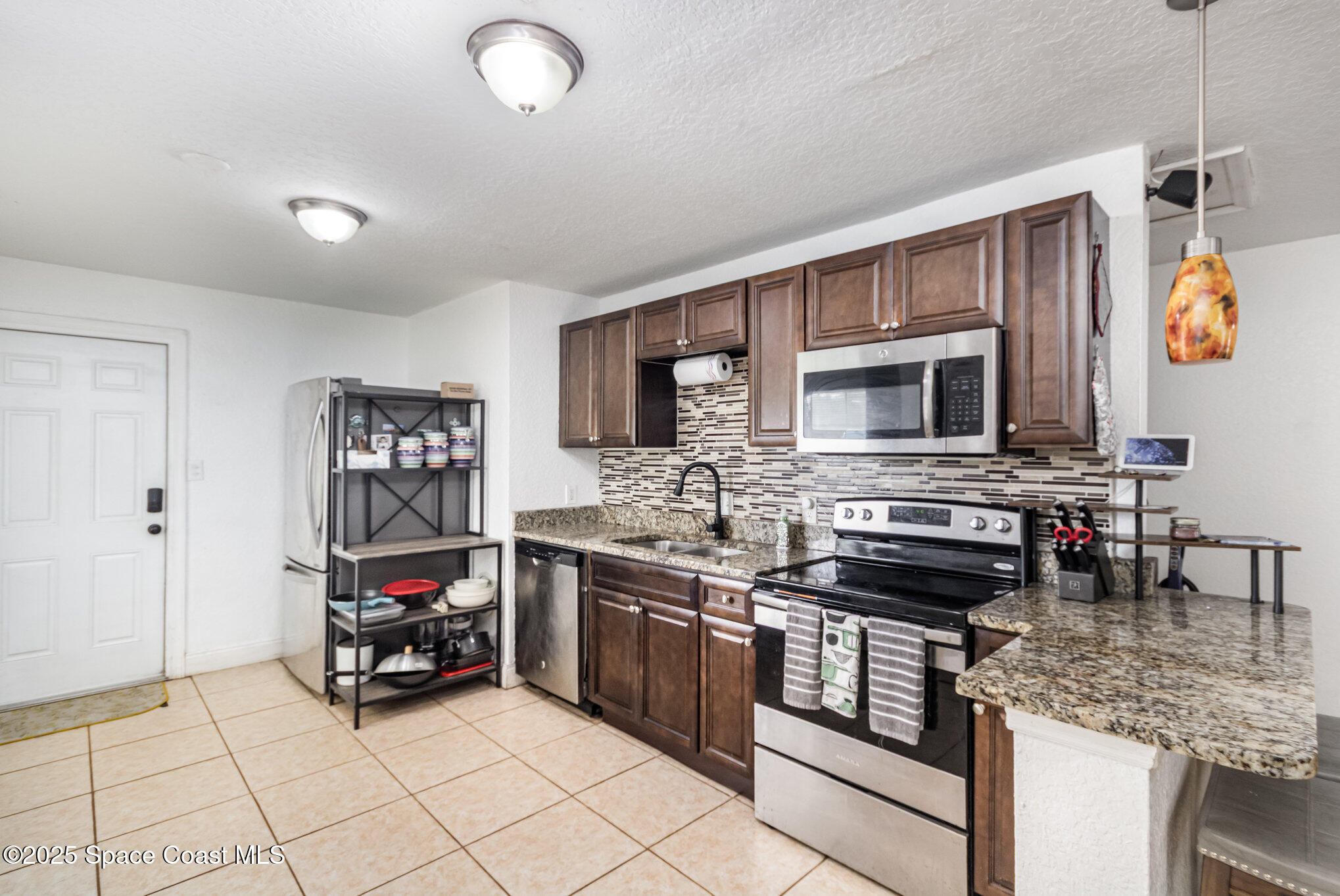 2004 High Street Leesburg, FL 34748 - Photo 11 of 30 a kitchen with stainless steel appliances kitchen island granite countertop a stove and a sink