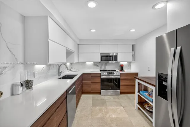 a kitchen with stainless steel appliances a refrigerator sink and stove