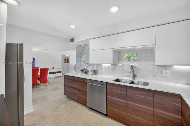 a kitchen with stainless steel appliances sink refrigerator and window