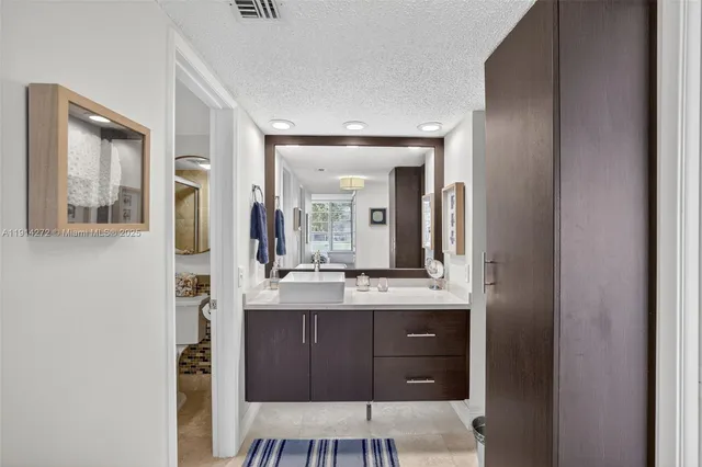 a bathroom with a granite countertop sink and a mirror