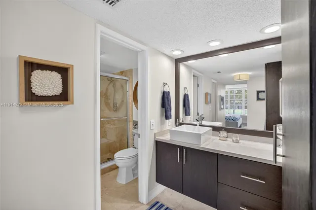 a bathroom with a double vanity sink toilet and shower