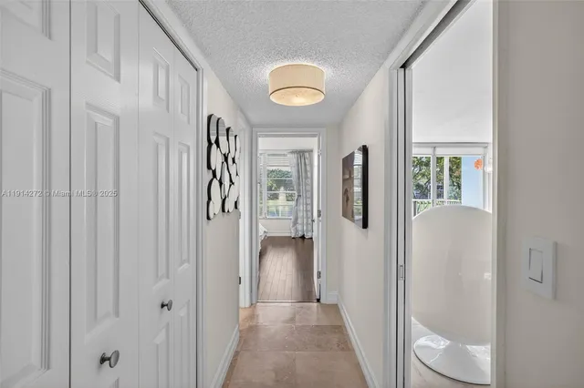 a view of a hallway with wooden floor and entryway
