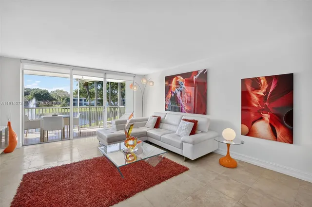 a living room with furniture a rug and a large window