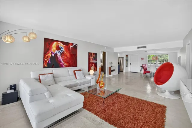 a living room with furniture and a view of kitchen