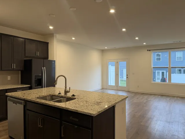 a kitchen with stainless steel appliances granite countertop a sink stove and refrigerator
