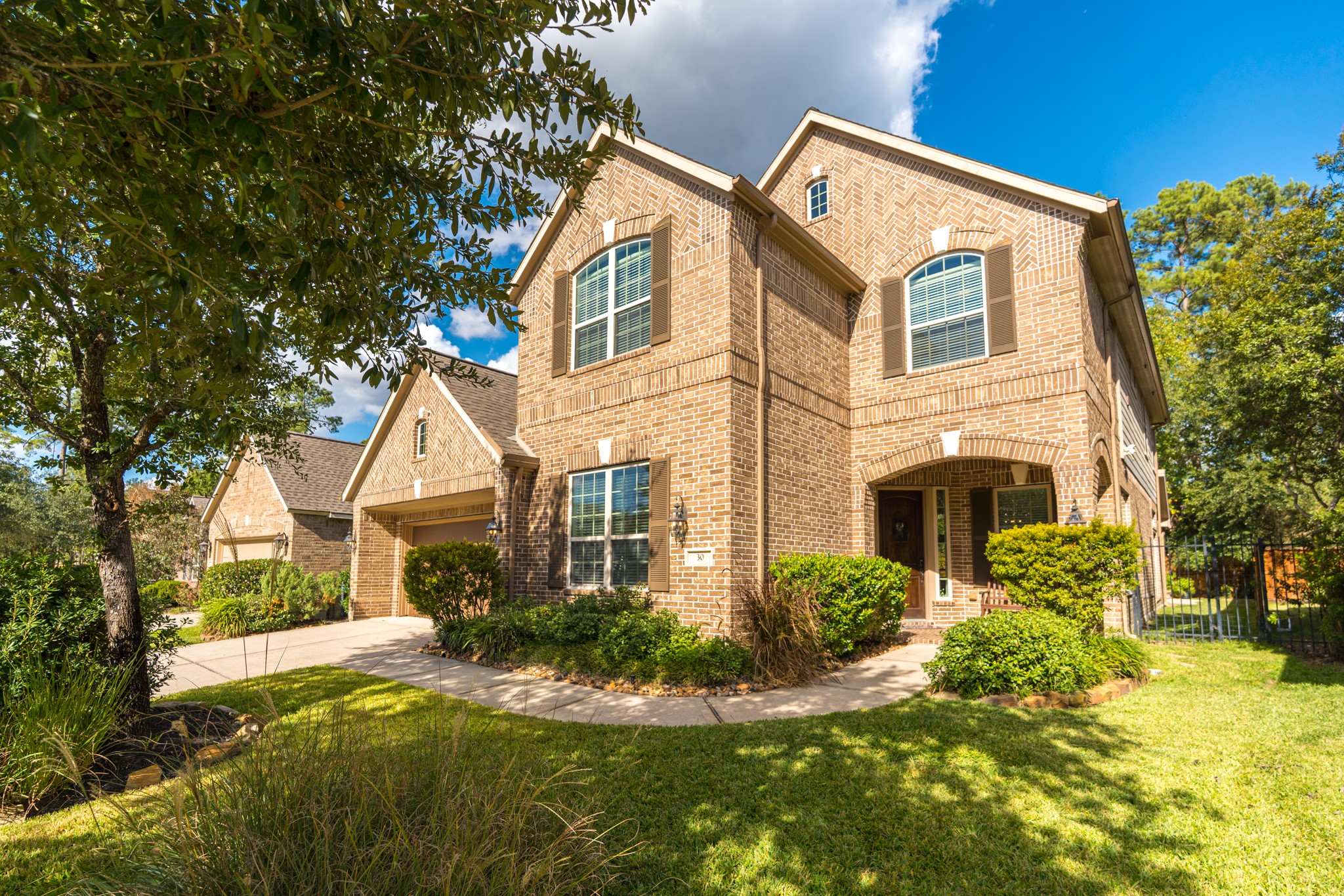 30 Fury Ranch Place The Woodlands, TX 77375 - Photo 8 of 47 This is a beautiful two-story brick home with a well-maintained lawn and lush landscaping. It features a large driveway leading to a double garage, and the facade is accented with large windows and a welcoming front entrance. Perfect for families seeking a spacious and inviting property.