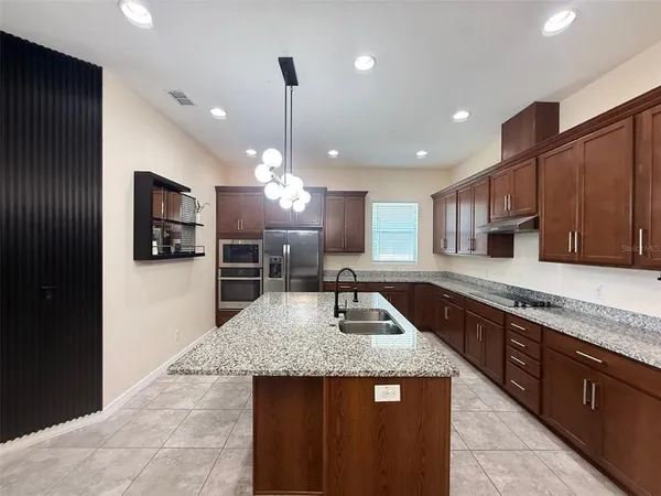 a kitchen with granite countertop counter top space a sink stainless steel appliances and cabinets