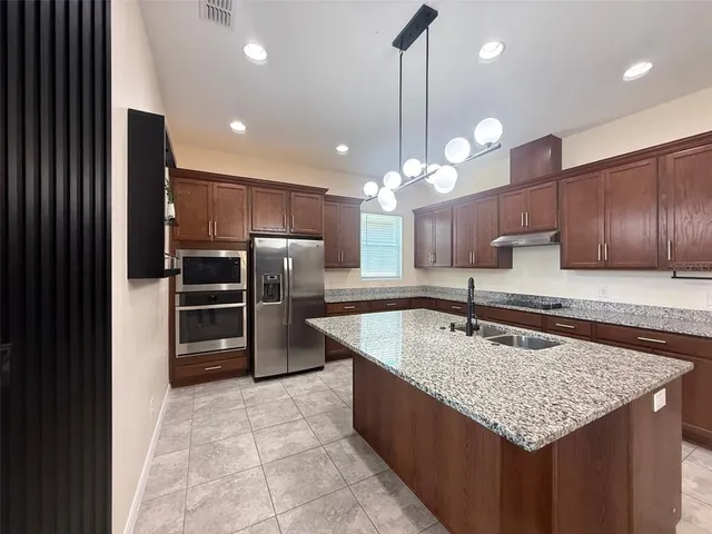 a kitchen with center island a counter space stainless steel appliances and cabinets