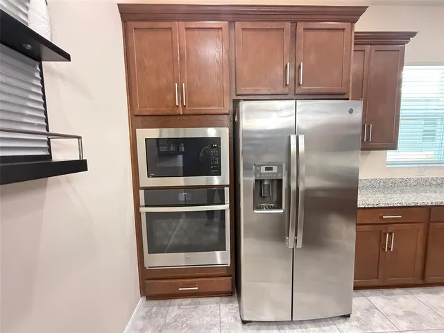 a kitchen with granite countertop stainless steel appliances and a refrigerator