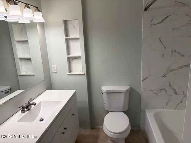 a white toilet sitting next to a bath tub and a shower