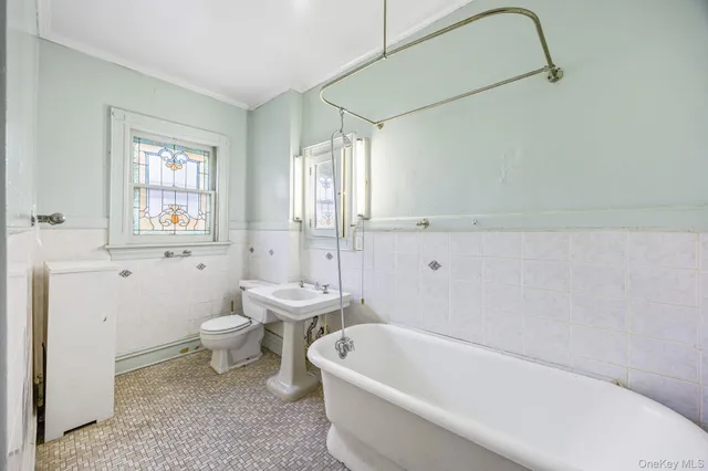 a bath room with a toilet a bath tub and a shower