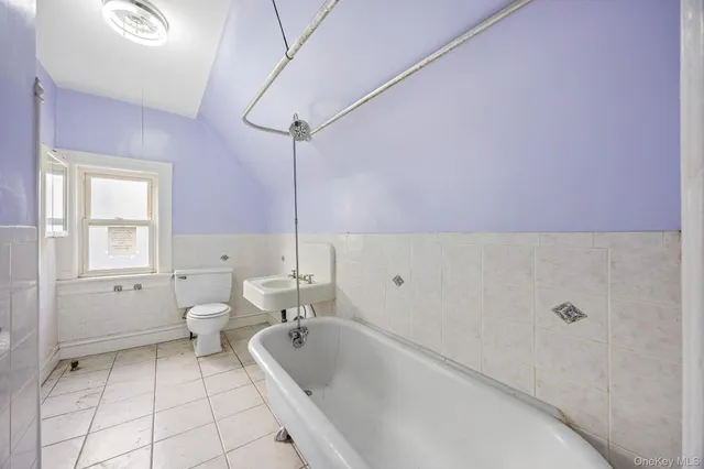 a bathroom with a tub sink and toilet