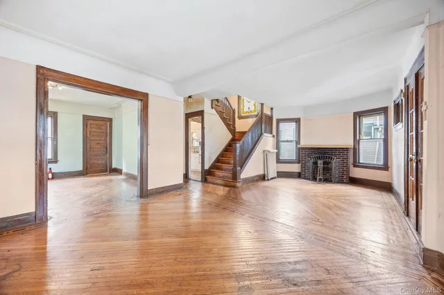 a view of a livingroom with furniture wooden floor staircase and a way to kitchen