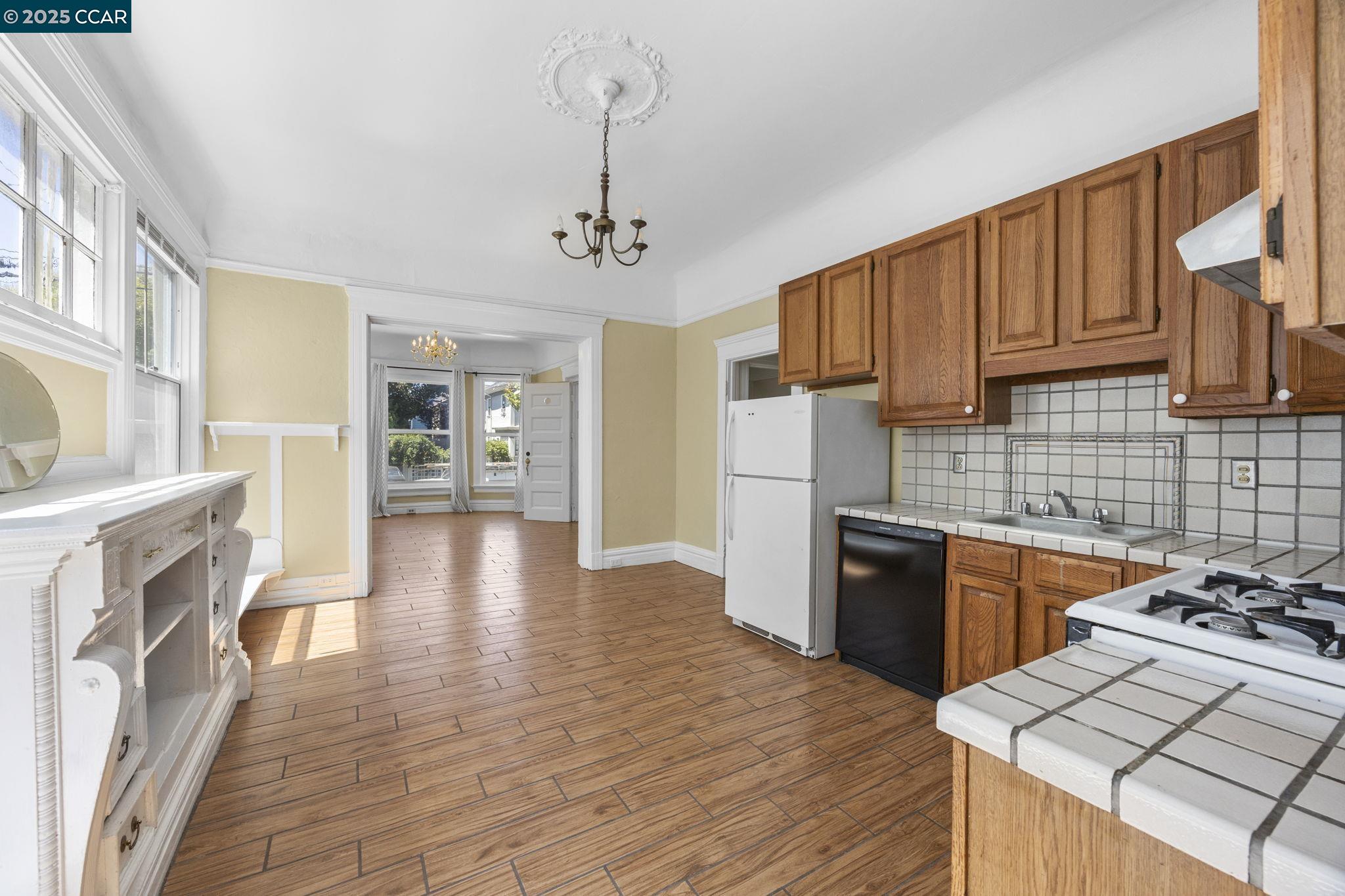 1220 Chestnut Street Alameda, CA 94501 - Photo 13 of 29 a kitchen with granite countertop a stove top oven a sink dishwasher and a refrigerator with wooden floor
