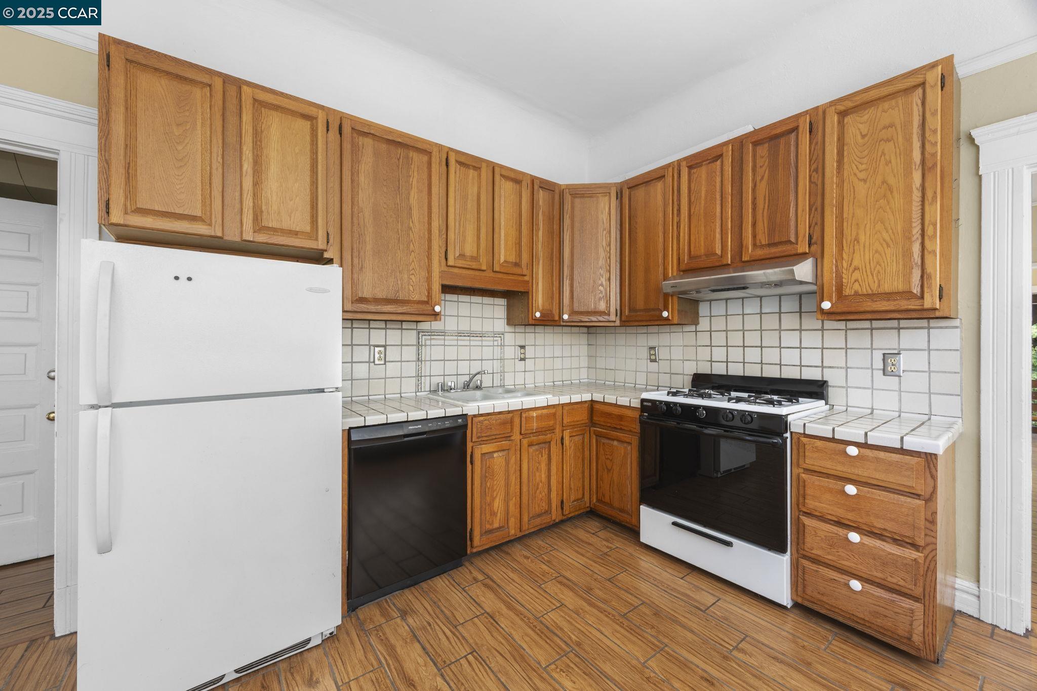1220 Chestnut Street Alameda, CA 94501 - Photo 10 of 29 a kitchen with granite countertop wooden cabinets and white appliances