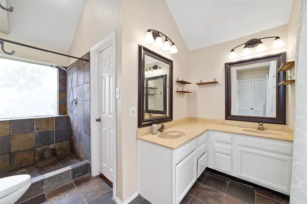 a bathroom with a double vanity sink mirror and shower