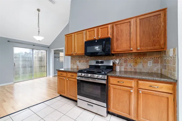 a kitchen with stainless steel appliances granite countertop a stove a sink and a microwave