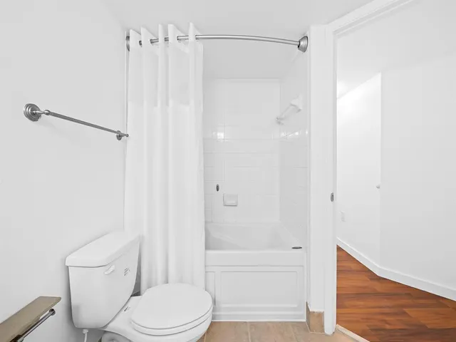 a bathroom with a shower a toilet and sink