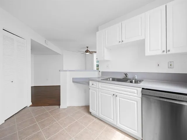 a kitchen with granite countertop white cabinets and white appliances