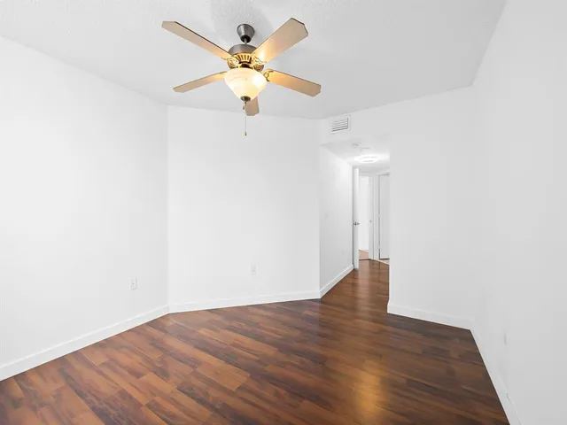 an empty room with wooden floor and a window
