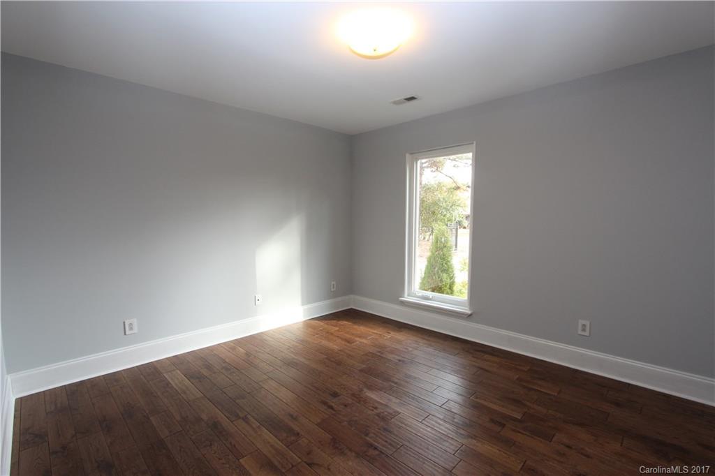 101 Heathwood Road Charlotte, NC 28211 - Photo 18 of 24 an empty room with wooden floor and windows