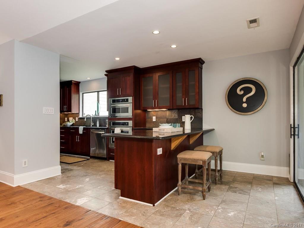 101 Heathwood Road Charlotte, NC 28211 - Photo 5 of 24 a kitchen with granite countertop cabinets a sink a stove a oven a dining table and chairs