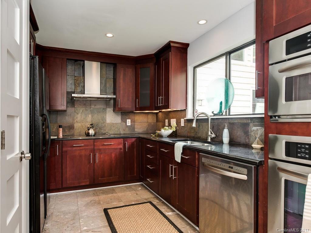 101 Heathwood Road Charlotte, NC 28211 - Photo 6 of 24 a kitchen with stainless steel appliances granite countertop wooden cabinets a sink and a stove
