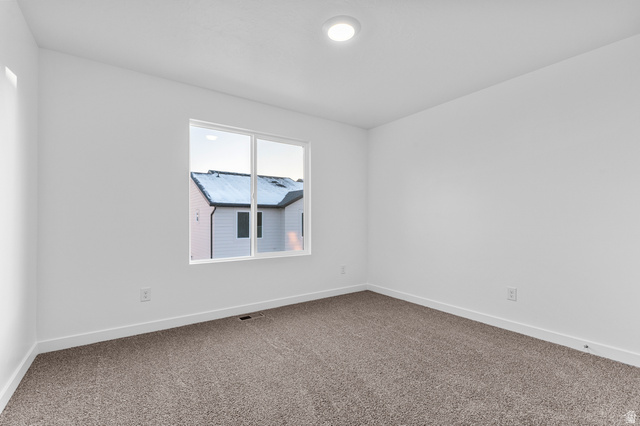 2829 North 710 West, Unit 15 Logan, UT 84321 - Photo 15 of 23 Bright interior space featuring a window with white framing, neutral carpet flooring, white baseboards, and a recessed ceiling light fixture