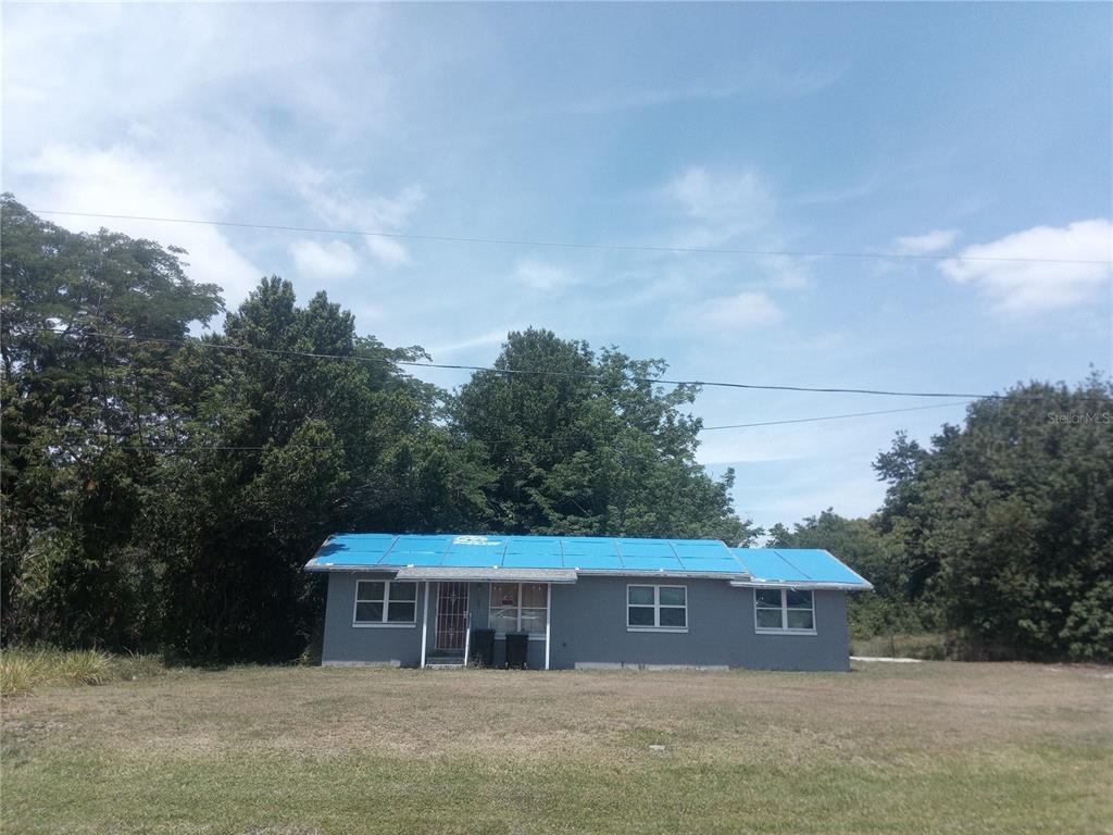 a front view of house with yard and trees in the background
