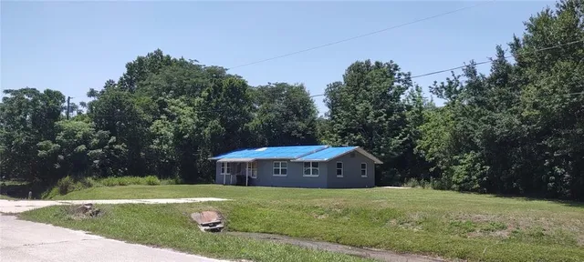 a view of a back yard with green space and wooden fence